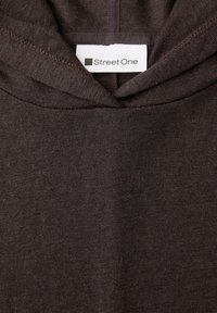 Kaptur z ciemnobrązowego dzianego materiału z dekoltem, na którym widoczna jest przyszyta biała metka marki z napisem "Street One".