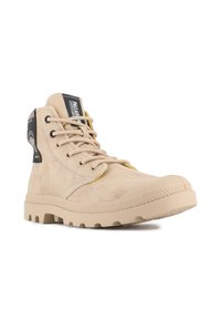 Botas altas beige hechas de lona con un acabado texturizado. Presentan una puntera redonda de goma y acentos amarillos en contraste en los cordones.