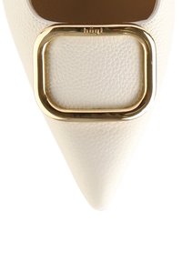 Talon aiguille en cuir blanc à bout pointu, ornée d'une grande boucle carrée dorée sur le devant, avec une surface texturée et une semelle intérieure marron.