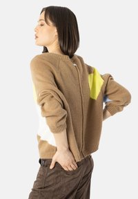 Brun strikket genser med gule og lyseblå accenter, med en avslappet passform, ribbede mansjetter og rund hals.