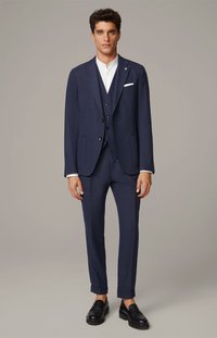 Marineblå skræddersyet jakkesæt med struktureret blazer, matchende bukser og hvid skjorte. Har to-knaps lukning og sidelommer. Sorte sko.