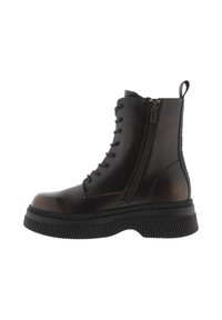 Botas de tobillo de cuero marrón con una suela de goma negra gruesa, que presentan cordones planos, un zipper lateral y una tira en la parte posterior para ayudar a ponérselas.