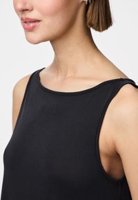 Μαύρο αμάνικο τοπ με ψηλό λαιμό και μαλακή υφή. Διαθέτει καμπυλωτό σχέδιο στους ώμους και απλή, λιτή εμφάνιση.