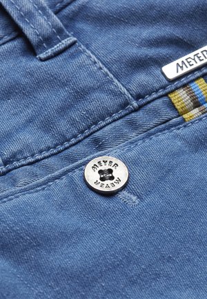 Denim broeken zijn gemaakt van een blauwe stof met een zachte textuur, een zilveren MEYER-knop en een gestreepte stofaccent in geel en bruin.