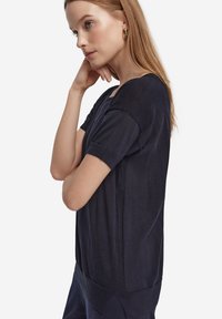 Granatowy, krótki sweter z okrągłym dekoltem, z teksturowanymi panelami bocznymi i lekko luźnym krojem. Gładka tkanina.