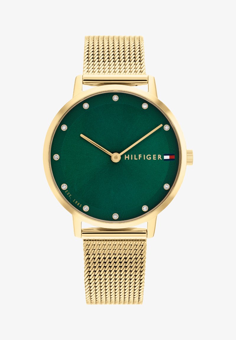 Relógio dourado com mostrador verde, doze marcadores de horas semelhantes a diamantes e bracelete de malha dourada. Apresenta o logótipo da marca em vermelho, branco e azul.