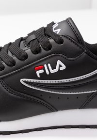 Black leather sneaker with white midsole, featuring black laces, silver accents, and a white and red logo on the side.