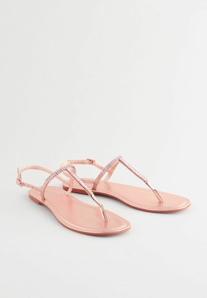 Ružovo-zlaté ploché sandále s dizajnom na medzi prst a nastaviteľným prackovým popruhom, s kovovým leskom a minimalistickým štýlom.