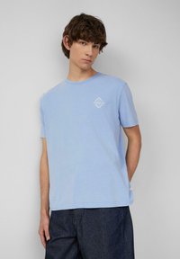 Lichtblauwe t-shirt van katoen, met een ronde halslijn en korte mouwen. Klein wit logo gedrukt op de linkerkant van de borst.