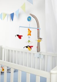 The image features a crib mobile with soft, colorful plush toys: bees and a flower, on a light blue frame with a beige arm.