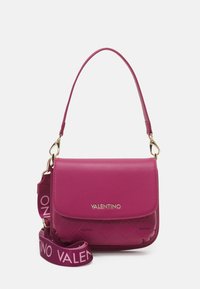 Rosa Valentino axelremsväska med quiltad nederdel, guldfärgad hårdvara och avtagbar bred rem med "Valentino" tryckt i ljusrosa.