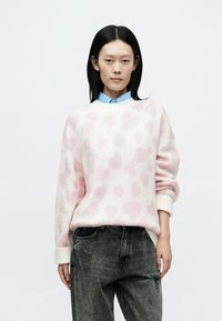 Rozā leoparda raksta džemperis ar baltu pamatu, ar gar�ām piedurknēm un apaļu izgriezumu, kombinēts ar pelēkām saplēstām džinsa biksēm.