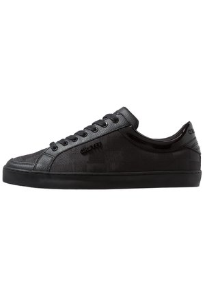 Baskets basses noires en tissu texturé et panneaux en cuir, lacets noirs et détails de marque sur le côté et le talon.