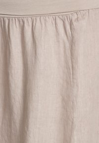 Helle beige Leinenrock mit geraffter Textur an der Taille und glatter Drapierung. Verfügt über einen elastischen Bund für einen bequemen Sitz.