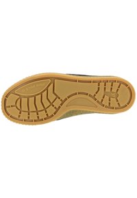 Black sneaker sole with thick rubber tread, featuring a textured surface and visible brand name "G-STAR RAW" on the side in light font.