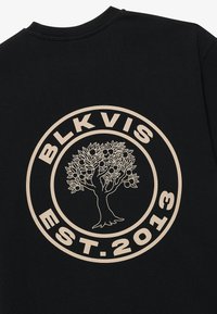 Čierna mikina so smotanovou kruhovou grafikou, na ktorej je text "BLKVIS" a zložitý dizajn stromu, založená v roku 2013.