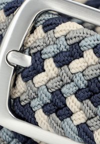 Pleciona paski w odcieniach granatowym, jasnoniebieskim, szarym i kremowym z metalową srebrną klamrą. Teksturowana powierzchnia i splątany wzór.