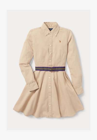 Beigefärgad bomullsklänning med knapplist framtill, långa ärmar, spetsig krage och ett flerfärgat randigt bälte runt midjan.