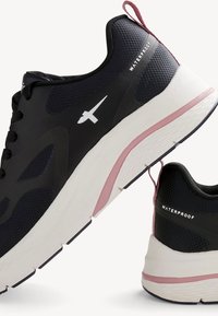Fekete vízálló sportcipők, texturált felsőrésszel, fehér részletekkel, párnázott középtalppal rózsaszín díszítéssel és megerősített sarkú tab-berendezéssel.