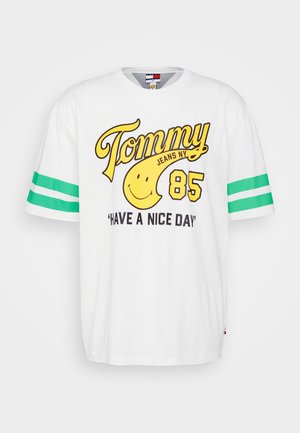 Weißes T-Shirt mit kurzen Ärmeln und grünen gestreiften Akzenten an den Ärmeln, mit gelbem grafischem Text und einem Smiley-Gesicht. Lässiger, lockerer Schnitt.