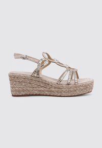 Sandali con zeppa beige con suola in juta intrecciata, dettagli delle cinghie con accenti metallici e fibbia alla caviglia regolabile.