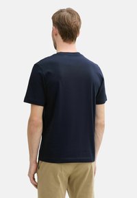 Dunkelblaues Baumwoll-T-Shirt mit rundem Ausschnitt und kurzen Ärmeln, mit normaler Passform und glatter Textur. Einfaches Design, ohne Muster.