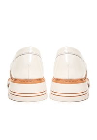 Chaussures en cuir verni blanc avec un profil bas, un bout arrondi et une semelle en caoutchouc, ornées de rayures beiges et de coutures contrastées.