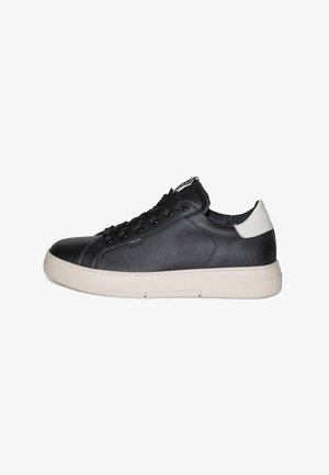 Sort lædersneaker med glat finish, snørelukning, hvid gummisål og kontrasterende hælaccent. Har minimal branding.