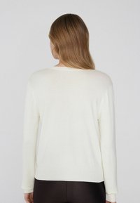 Witte lange mouwen trui met een ronde halslijn en geribbelde manchetten, met een gladde textuur en een relaxed fit.