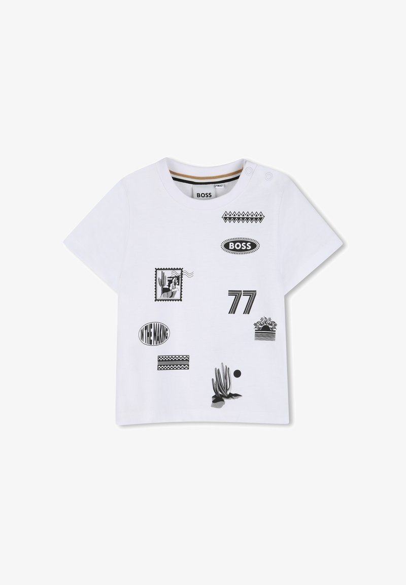 T-shirt blanc à manches courtes pour enfants, avec des imprimés graphiques noirs comprenant "BOSS", "77", un cactus, et le texte "IN THE MAKING", ainsi que des pressions à l'épaule.