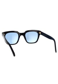 Occhiali da sole in plastica nera con lenti quadrate, tonalità blu e dettaglio dorato del logo sul lato. Linee pulite e finitura liscia, hardware minimale.