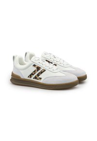 Sneaker bianche basse con suole in gomma marrone, lacci bianchi, punte in suede e dettagli con logo "T" a stampa leopardata sui lati.