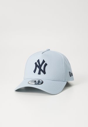 Gorra de béisbol azul claro con un logotipo bordado en azul marino. Presenta una visera curvada y una correa ajustable en la parte posterior. Textura de tela suave.