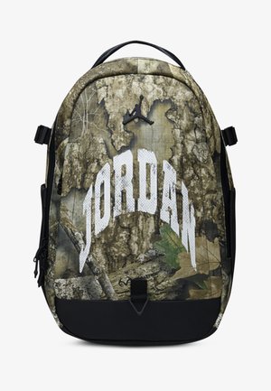 Kamuflāžas mugursoma ar melnu pamatni, uz kuras ir liels balts "JORDAN" logo. Tekstūrēts, izturīgs materiāls un regulējami siksniņas.