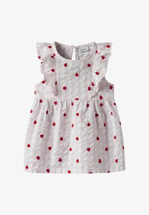 Light pink sleeveless dress with ruffled shoulders, featuring an all-over red heart pattern and textured fabric. Back button closure.