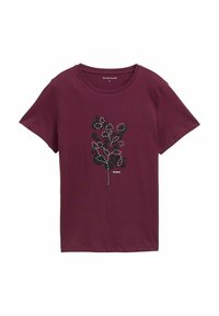 T-shirt en coton bordeaux à manches courtes, avec un motif floral noir souligné de blanc. Étiquette visible au col.