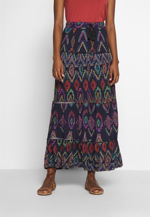 Falda maxi con patrones geométricos coloridos, diseño en capas y fondo azul marino. La tela es ligera y cuenta con una cintura ajustable.