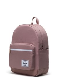 Pink backpack made of durable fabric, featuring a rounded top, front zip pocket with white zipper, and a logo patch on the front.