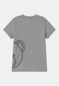 Šedé tričko s krátkým rukávem vyrobené z měkké bavlny, na levé straně ozdobené grafiku černého medvěda. Hladká textura a design s kulatým výstřihem.