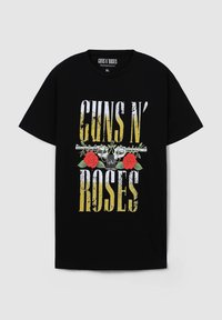 T-shirt in cotone nero con una grafica in bianco e giallo, usurata, che presenta il testo "GUNS N' ROSES" accompagnato da rose rosse e un design di pistola al centro.