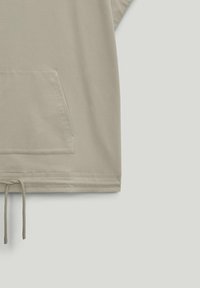 Sweat à capuche beige avec cordon de serrage à l'ourlet et poche avant. Le tissu semble doux avec une texture lisse et une coupe décontractée.