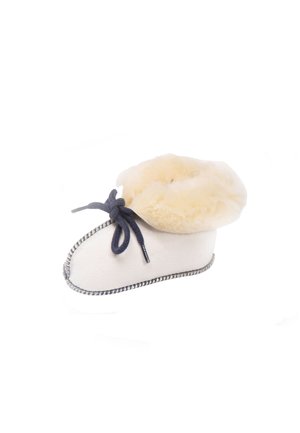 Lamswollen slippers in crème met een fluffy tan kraag. Voorzien van donkerblauwe veters en contrasterende stiksels langs de onderkant. Zachte textuur.