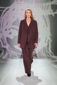 Blazer doppiopetto bordeaux con pantaloni a gamba larga abbinati. Tessuto liscio con un sottile lucentezza. Indossato con eleganti stivali neri con tacco.
