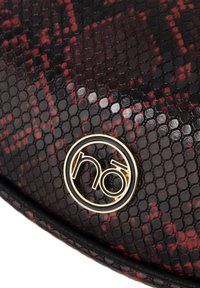 Borsa a mano nera e rossa con un esterno lucido e texturizzato, dotata di un logo circolare dorato e dettagli di design a rilievo.