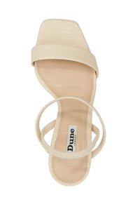 Beige sandaal met een getextureerde vierkante neus, dunne bandjes en een zachte, gladde binnenzool. Merklabel zichtbaar op de binnenzool.