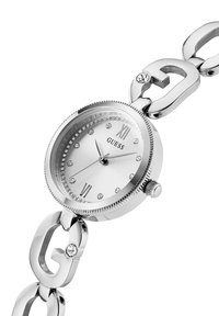 Silberne Guess-Armbanduhr mit Kristallakzenten auf Zifferblatt und Armbandgliedern, mit römischen Zahlen bei 12 und 6 Uhr.
