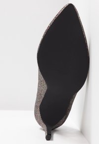 Chaussure à talon aiguille à bout pointu avec une tige en paillettes multicolores et une semelle noire lisse. Design élégant avec un talon stiletto.