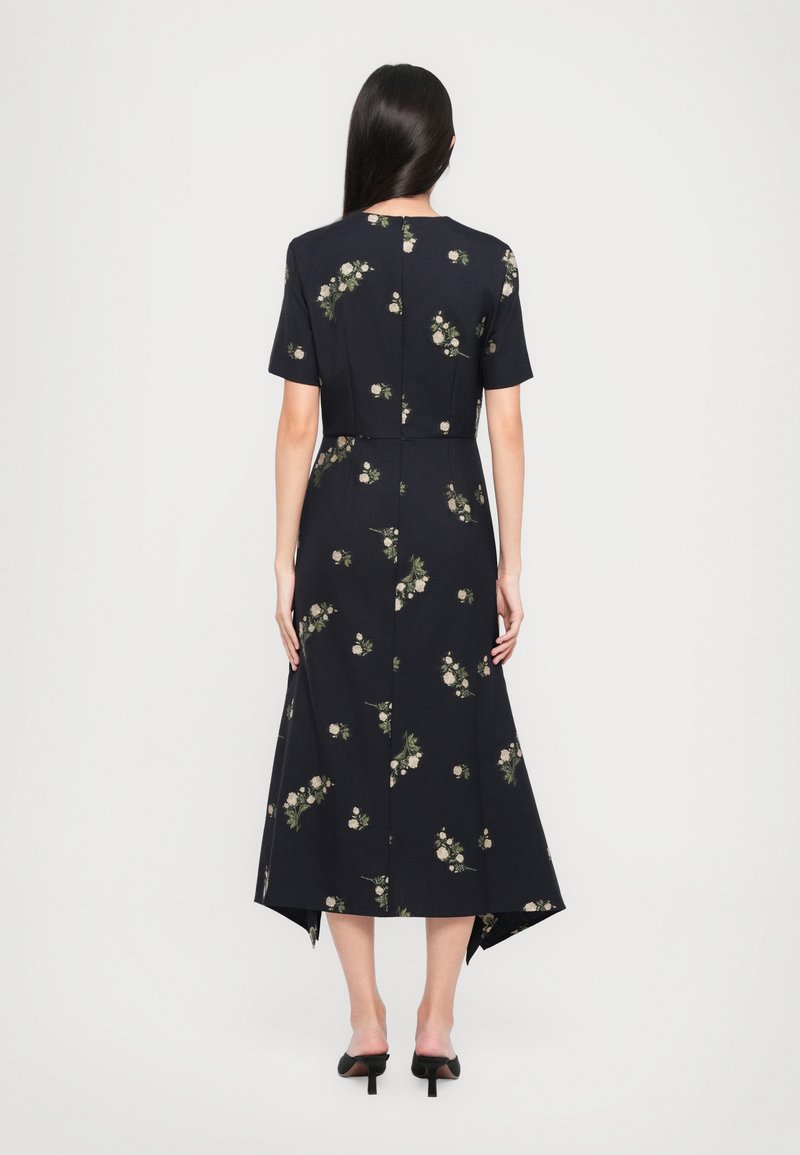 Robe marine avec un motif floral, manches courtes et un ourlet asymétrique. Fabriquée en tissu lisse avec une taille cintrée et une silhouette décontractée.