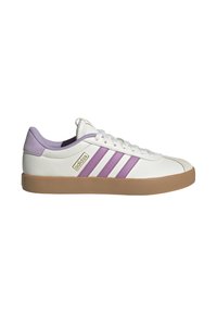 Zapatillas blancas con rayas y acentos morados, que cuentan con una superficie texturizada y una suela de goma marrón. El logo es visible en un lado.