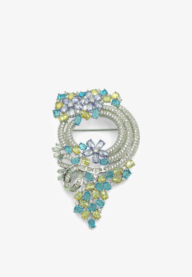 Broche circulaire avec pierres précieuses bleues, jaunes et violet clair, boucles en argent et motifs floraux sur fond blanc.